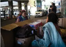  ?? ?? Social Worker Silvana Amaral (left) talks with a homeless woman during a visit of Consultori­o de Rua health team to a homeless encampment under the Madureira viaduct, located in north Rio de Janeiro.