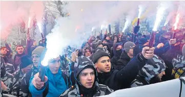  ??  ?? Protesters yesterday lit flares as they protested against Russia at Ukraine’s parliament in Kiev