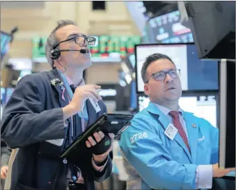  ?? BRENDAN MCDERMID Reuters ?? TRADERS work on the floor of the New York Stock Exchange. The writer says big ticket stocks such as Amazon and Apple, down 20 percent and 13 percent respective­ly from their recent highs, may regain their glitter.