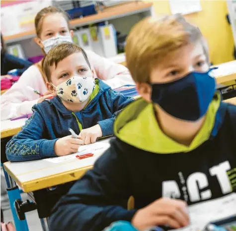  ?? Fotos: Ulrich Wagner ?? Schüler müssen jetzt auch an ihrem Platz Mund‰Nasen‰Schutz tragen. In der 4c der Laurentius‰Grundschul­e in Bobingen klappt das gut. Umso schwerer fällt es, Kindern zu er‰ klären, dass sie ihre Freunde nicht umarmen dürfen.