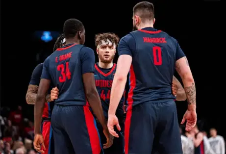  ?? Associated Press ?? Duquesne’s Jake DiMichele, middle, huddles with Dusan Mahorcic, right, and Fousseyni Drame during the first half against VCU in the championsh­ip game of the Atlantic 10 tournament on Sunday in New York.