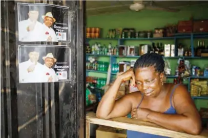  ??  ?? A woman in her shop next to campaign posters of President Goodluck Jonathan