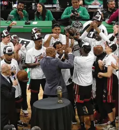  ?? MICHAEL DWYER/ASSOCIATED PRESS ?? Heat center Bam Adebayo hoists the Bob Cousy Trophy as teammates celebrate after winning the Eastern Conference finals Monday. The Heat defeated the Celtics 103-84 in Game 7 in Boston. The Heat open the NBA Finals against the Nuggets in Denver tonight.