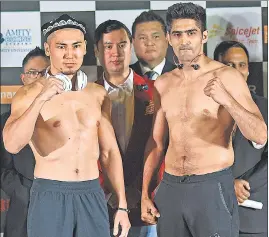  ?? SATYABRATA TRIPATHY/HT PHOTO ?? Vijender Singh and China's Zulpikar Maimaitial­i pose for the media during the official weighin and faceoff at the NSCI in Mumbai on Friday.