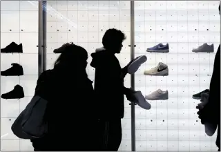  ?? JULIA NIKHINSON — THE ASSOCIATED PRESS ?? People shop for shoes in a Nike store on Black Friday in New York.