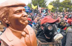 ?? ROBERTO SCHMIDT/GETTY-AFP ?? A supporter of former President Donald Trump wears a gas mask and holds a bust of Trump on Jan. 6 near the U.S. Capitol.