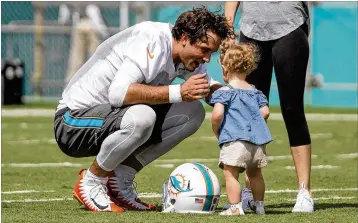  ?? ALLEN EYESTONE / THE PALM BEACH POST ?? Miami Dolphins quarterbac­k Brock Osweiler catches a moment with his daughter after the first day of training camp Thursday in Davie. Osweiler is competing to be the backup QB.