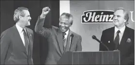  ?? Joyce Mendelsohn/Post-Gazette ?? Nelson Mandela acknowledg­es an audience that gathered to hear him speak in Oakland in 1991. He is flanked by former University of Pittsburgh president J. Dennis O’Connor, left, and Anthony J.F. O’Reilly, then the chairman of H.J. Heinz Co.