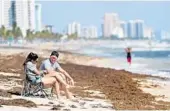  ?? AMY BETH BENNETT/SOUTH FLORIDA SUN SENTINEL ?? Ariana McAllister and Jeremy Rhoades sit on Fort Lauderdale beach Friday where red tide concentrat­ion is low.