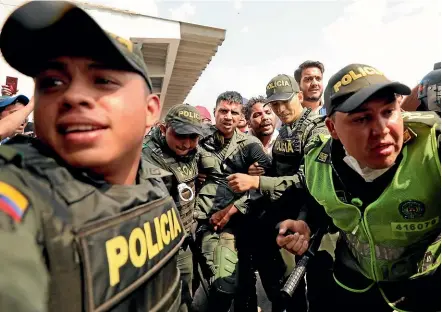  ?? AP ?? Colombian police escort a Venezuelan soldier who surrendere­d at the Simon Bolivar internatio­nal bridge, where Venezuelan­s tried to deliver humanitari­an aid despite objections from President Nicolas Maduro.