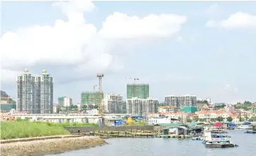  ??  ?? Small fishermen’s homes are seen in Daya Bay district next to new buildings under developmen­t in Huizhou in China’s Guangdong province. Investors are rushing in to a sleepy city on the southern coast of China thanks to a government policy that has seen...