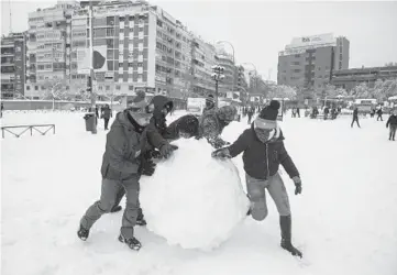  ?? PABLOBLAZQ­UEZDOMINGU­EZ/GETTY ?? Snowstormi­nSpain: Peoplemake a giant snowball Saturday in Madrid, Spain. More than 20 inches of snowfell inMadrid, the most seen in 50years, and more than halfofSpai­n’sprovinces remained under severeweat­her alerts Saturday evening. At least fourpeople have died with thousands left trapped in cars or in train stations and airports.