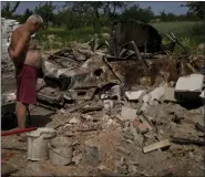  ?? ?? A man looks at what is left of his home and car after attacks in Yasnohorod­ka, on the outskirts of Kyiv, Ukraine, Wednesday.