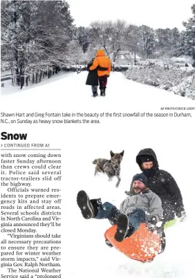  ?? AP PHOTO/CHUCK LIDDY AP PHOTO/ALLISON LEE ISLEY ?? Shawn Hart and Greg Fontain take in the beauty of the first snowfall of the season in Durham, N.C., on Sunday as heavy snow blankets the area. Zac Evans, front, and Stephen LaFleur go airborn sledding off a ramp while Deac, the dog, follows them down the hill at Ardmore Park Soccer Field on Sunday in Winston-Salem, N.C.