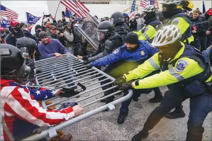  ?? JOHN MINCHILLO / AP ?? Supporters of President Donald Trump try to break through a police barrier Wednesday at the U.S. Capitol. As Congress prepared to affirm President-elect Joe Biden’s victory, thousands of Trump supporters overran police and stormed the Capitol, causing an hourslong delay in Congress’ constituti­onal duty to accept the Electoral College’s results.