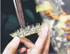  ?? ?? Thuc cutting a piece of fabric for an artwork in her home studio