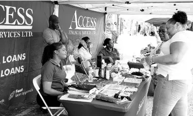  ?? CONTRIBUTE­D PHOTOS ?? Access Financial Services (AFS) customer and jewellery maker Keisha Grant (left) speaks with patrons inside the AFS booth at a recent small business expo in Junction, St Elizabeth.