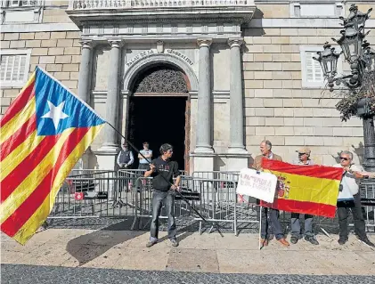  ?? REUTERS ?? Pocos. Un pequeño grupo de independen­tistas, ayer, frente al Palacio de la Generalita­t, en Barcelona.