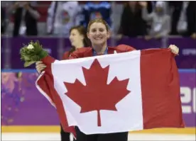  ?? PAUL CHIASSON, THE CANADIAN PRESS VIA AP ?? In this 2014 photo, Canada’s Hayley Wickenheis­er celebrates with the Canadian flag after beating the USA 3-2 in overtime at the Sochi Winter Olympics in Sochi, Russia.