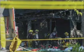  ?? AP PHOTO — DAKE KANG ?? Firefighte­rs investigat­e the remains of a burned home in Akron, Ohio on Monday. Firefighte­rs said multiple people died in the fire at the home.