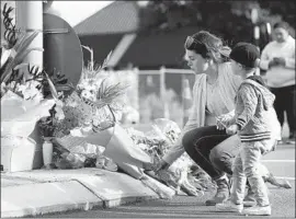  ?? Fiona Goodall Getty Images ?? MOURNERS in Christchur­ch, New Zealand, lay f lowers at a memorial to the 49 people killed at two mosques. Video of the shootings was spread on social media.