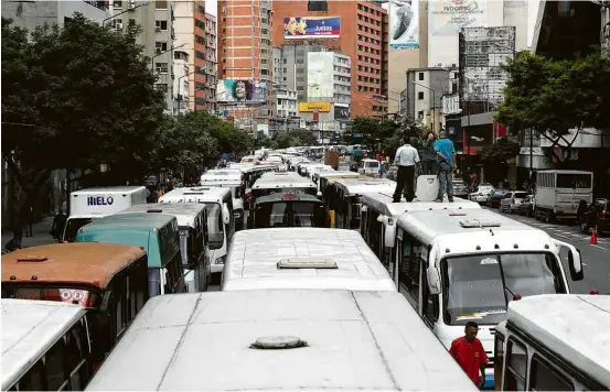  ?? Marco Bello/Reuters ?? Ônibus bloqueiam avenida durante protesto contra o censo de veículos estipulado pelo regime de Nicolás Maduro, em Caracas