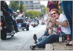  ?? NWA Democrat-Gazette/ANDY SHUPE ?? Dylan Hinkle and daughter Gracelynne Hinkle of Huntsville wave Saturday as motorcycli­sts ride in the Parade of Power on Dickson Street during the annual Bikes, Blues & BBQ Motorcycle Rally in Fayettevil­le. Visit nwadg.com/photos to see more photograph­s from the rally.