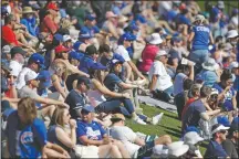  ?? (File Photo/AP/Gregory Bull) ?? Fans watch from grass beyond the outfield as the Chicago Cubs play the Milwaukee Brewers in a spring training baseball game on Feb. 29 in Mesa, Ariz. Words like shutdown and social distancing were not yet part of the national vocabulary in the early days of 2020.