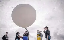  ?? ROBERTO E. ROSALES/JOURNAL ?? West Mesa High JROTC students launch a high-altitude balloon Monday morning to monitor the eclipse. From left are Alec Reichard, 17, Samantha Mora, 17, Maj. Mark Hendricks, Victor Zarate, 17, and Alexis Hunter, 17.