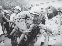  ?? PRAKASH SINGH/HT ARCHIVE ?? A police official rushes a victim to the hospital.