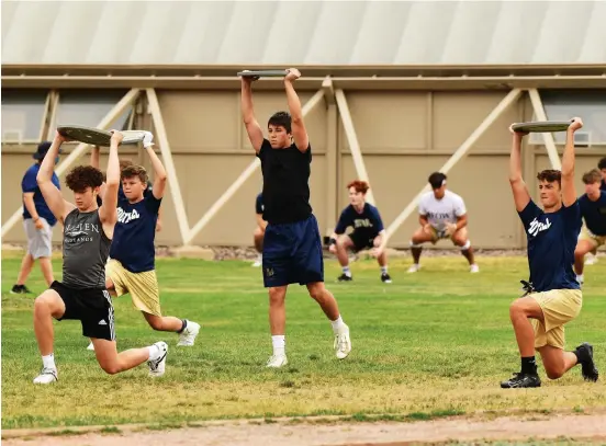  ?? Photos by Hyoung Chang, The Denver Post ?? Mullen High School football players stay 6 feet apart on Thursday during practice in Denver.