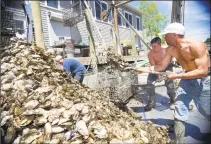  ?? Hearst Connecticu­t Media file photo ?? From left, Capt. Steve Hopkins, Patrick McGlone and Rene Euceda unload oysters from a boat at Norm Bloom &amp; Son in Norwalk.