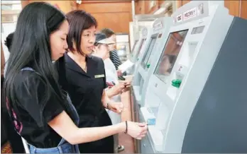  ?? LI HE / FOR CHINA DAILY ?? Customers use facilities at an outlet of Industrial & Commercial Bank of China Ltd in Beijing.