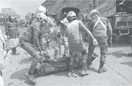  ?? / AP ?? ■ RESCUE: Ning handout nga hulagway nga gihatag sa Lungsod sa Monkayo, mga rescuer nagyayong sa usa sa mga biktima sa landslide nga dala sa pagbunok sa uwan sa lungsod sa Davao de Oro province, sa southern Philippine­s.