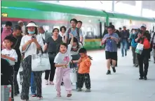  ?? XING GUANGLI / XINHUA ?? Passengers of the D887 train, which departed from Kunming, Yunnan, arrive at the station in Vientiane on April 13.