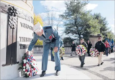  ?? MICHAEL MCANDREWS/HARTFORD COURANT ?? Franco American War Veterans Post Cmdr. Mark Morin lays a wreath at the base of New Britain’s World War I monument at Walnut Hill Park on Veterans Day to mark the 100th anniversar­y of the end of the first World War.