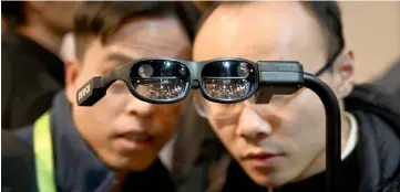  ?? — AFP photo ?? Attendees look at NReal augmented reality (AR) glasses, on the last day of CES 2019, at the Las Vegas Convention Center in Las Vegas, Nevada. The user can see their environmen­t while wearing Augmented reality (AR) glasses, which blend virtual images with real-world objects.