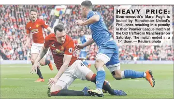  ??  ?? Bournemout­h’s Marc Pugh is fouled by Manchester United’s Phil Jones resulting in a penalty in their Premier League match at the Old Trafford in Manchester on Saturday. The match ended in a 1-1 draw. — Reuters photo