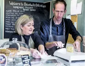  ??  ?? Nicola and David Riley wrap one of the local cheeses they sell at Bramhalls Deli.