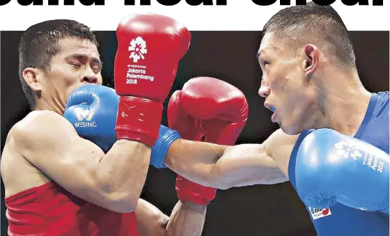  ?? REUTERS ?? Rogen Ladon of the Philippine­s connects on a right against Yuttapong Tongdee of Thailand during the men’s boxing flyweight semifinals of the 18th Asian Games in Jakarta, Indonesia yesterday. The Filipino fighter won, clinching a silver and advancing to the finals. Story on Page 18.