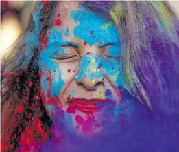  ??  ?? A woman bombarded with colours during Holi celebratio­ns.