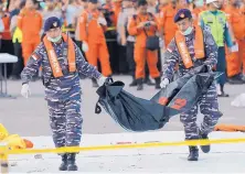  ?? TATAN SYUFLANA/ASSOCIATED PRESS ?? Navy personnel carry the remains of a victim of the Lion Air jet that crashed into the sea at the Tanjung Priok Port in Jakarta, Indonesia, on Oct. 29. All 189 people on board were killed.