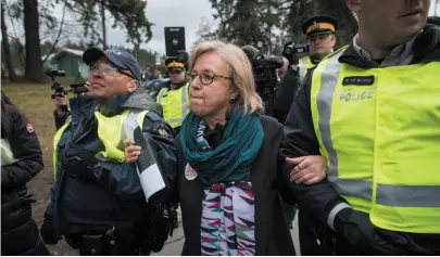  ?? CP PHOTO ?? Federal Green Party Leader Elizabeth May, centre, is arrested by RCMP officers after joining protesters outside Kinder Morgan’s facility in Burnaby on Friday. Protesters have been gathering all week – defying a court order – to protest the Kinder...