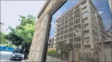  ?? REUTERS ?? The Pakistan Stock Exchange building is reflected in the bullet-riddled window of the security n check post after the attack in Karachi on Monday. >>P15