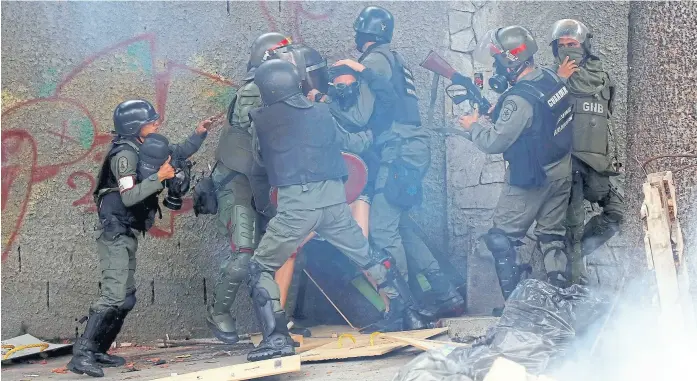  ?? Carlos garCía rawlins/reuters ?? Un manifestan­te es detenido, ayer en Caracas, durante una huelga convocada en contra del gobierno de Maduro