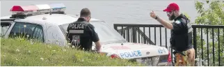  ?? PHIL CARPENTER ?? A pair of Montreal police officers at the scene near the St. Lawrence River, where coast guard officials found a body washed up in Pointeaux-Trembles Friday. Police say the sex still has to be determined.