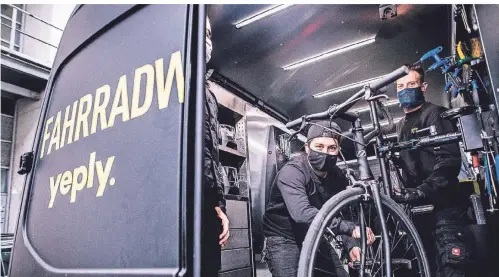  ?? FOTO: ANNE ORTHEN ?? Fahrradwer­kstatt im Van (v.l.): Patrick Phillips-Laneve und Mike Uhlmann von Yeply bei der Arbeit.