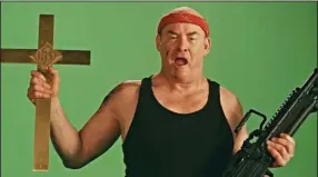  ??  ?? In the parody “Faith-Ba$ed,” David Koechner stars as Butch Savage, an ’80s action star who takes on the role of God in a cynical movie made by two 30-something Los Angelenos to cash in on the demand for Christian-theme films.