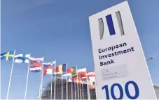  ?? — Reuters ?? Flags are seen behind the logo of the European Investment Bank pictured in the city of Luxembourg.