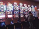  ?? ASSOCIATED PRESS ?? Gamblers try their luck at slot machines.
